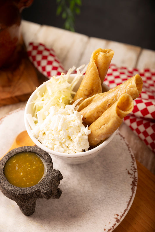 Flautas ahogadas en encacahutado con crema, queso y lechuga